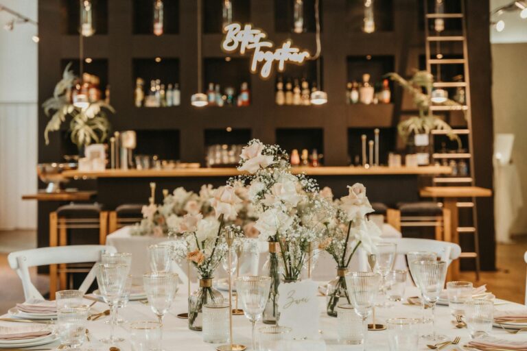 Intricate floral arrangements at a chic wedding reception bar setup.
